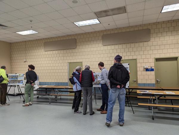 Photo of people in a school cafeteria attending the first JP open house