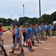 girls congratulating each other at the end of a softball game