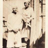 Two women pose on staircase