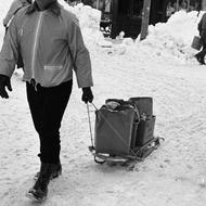 Unidentified volunteer pulling sled full of paper bags on Salem Street