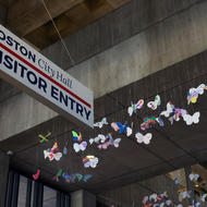 Butterflies to the right of a Visitor sign on the 3rd floor of Boston City Hall